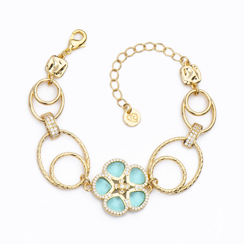 Bracciale con centrale a fiore in cristallo verde acqua ed elementi ovali in brass dorato lisci e diamantati alternati - Misura Regolabile