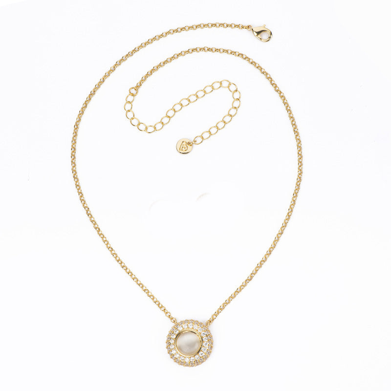 Collana con catenina rolò in brass dorato con pendente a bottone in cat eye avorio e pavè di zirconi clear - misura regolabile