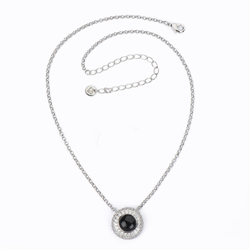 Collana con catenina rolò in brass rodiato con pendente a bottone in cat eye onice e pavè di zirconi clear - misura regolabile