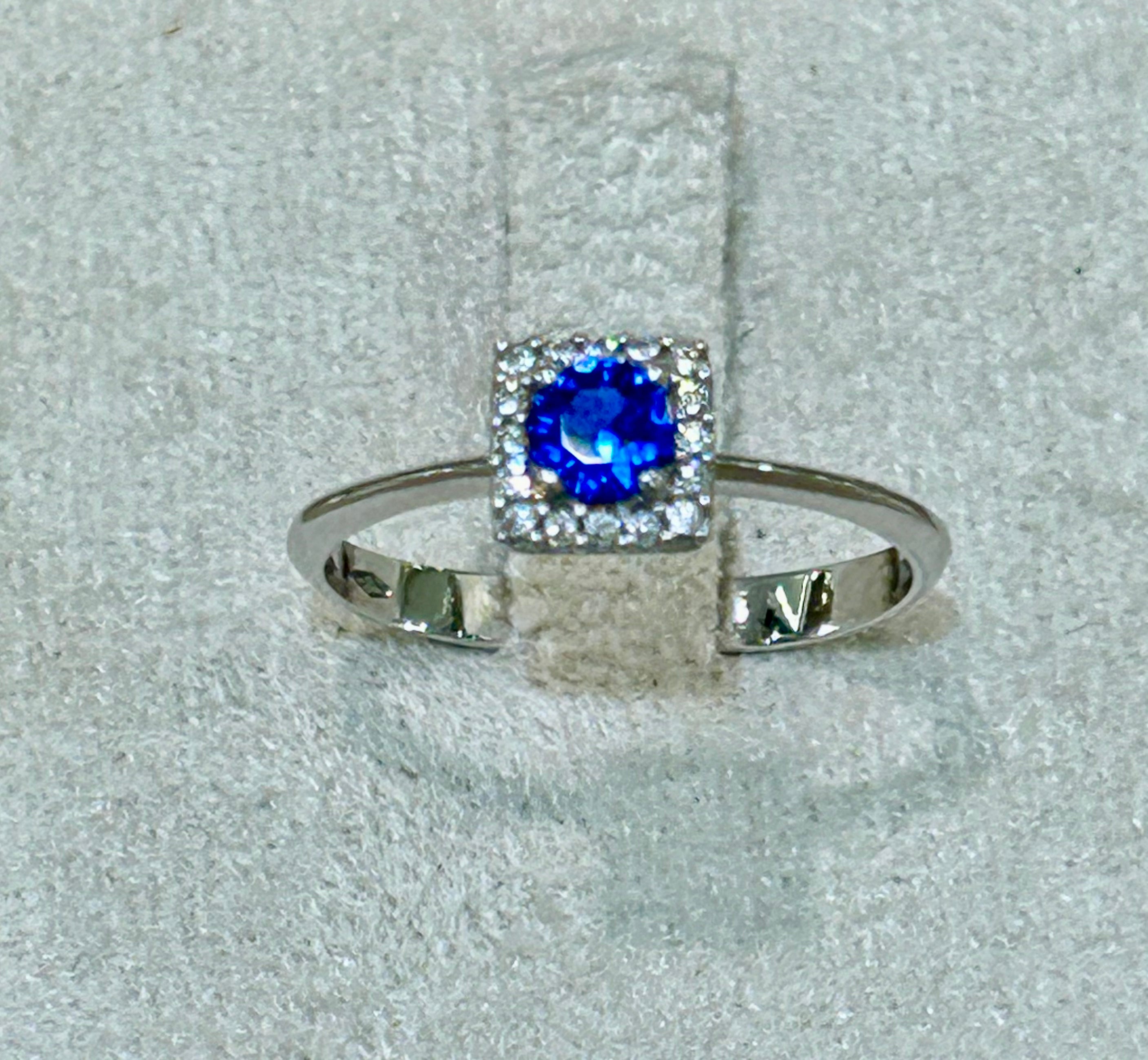 Anello in oro bianco 18 kt con topazio blu e giro di zaffiri bianchi