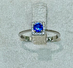 Anello in oro bianco 18 kt con topazio blu e giro di zaffiri bianchi