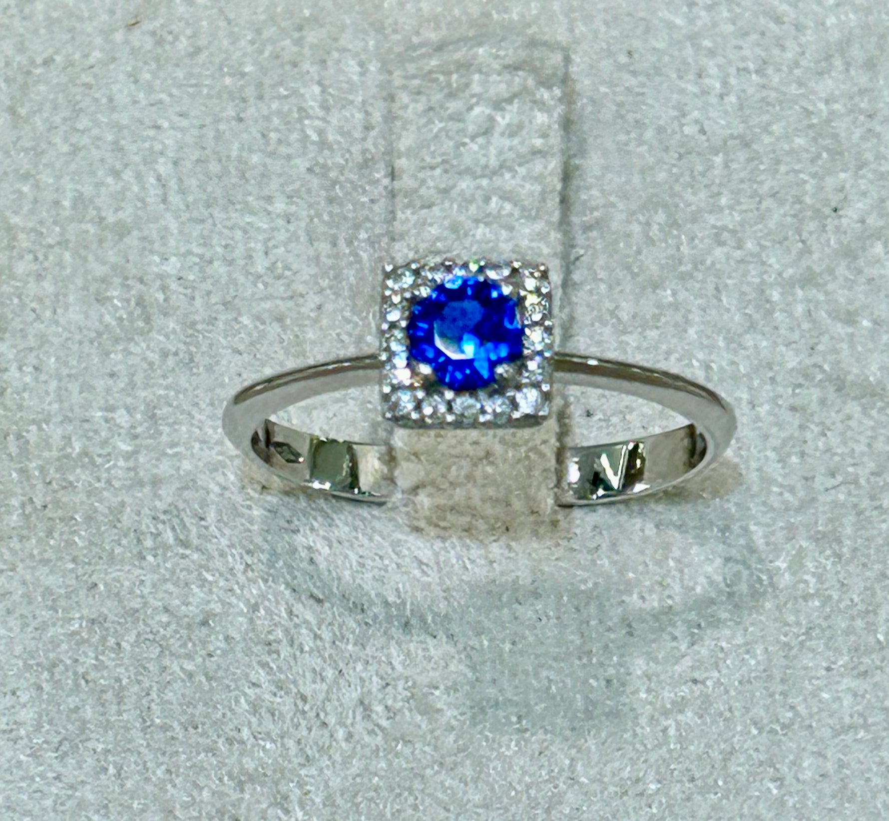 Anello in oro bianco 18 kt con topazio blu e giro di zaffiri bianchi