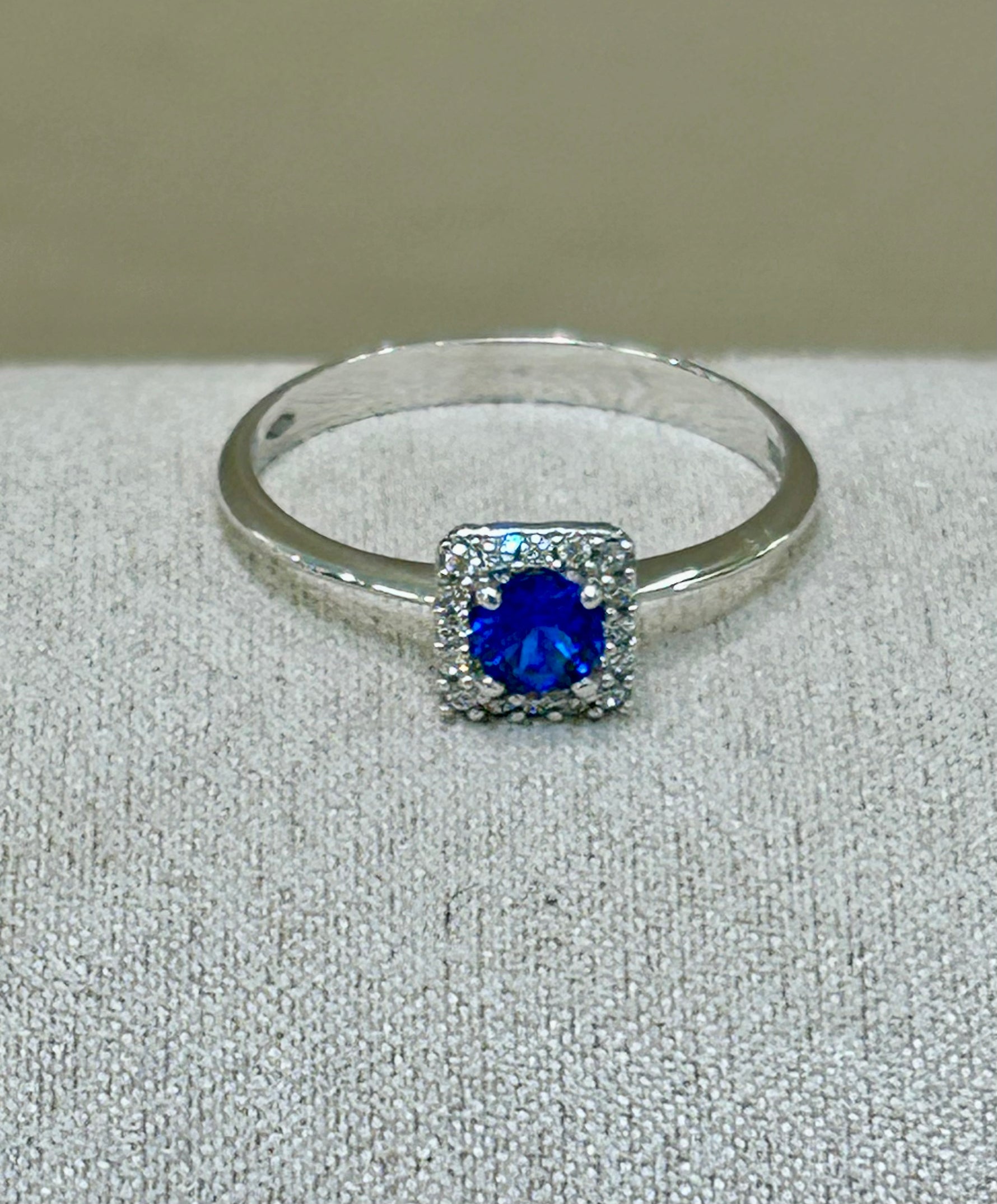 Anello in oro bianco 18 kt con topazio blu e giro di zaffiri bianchi